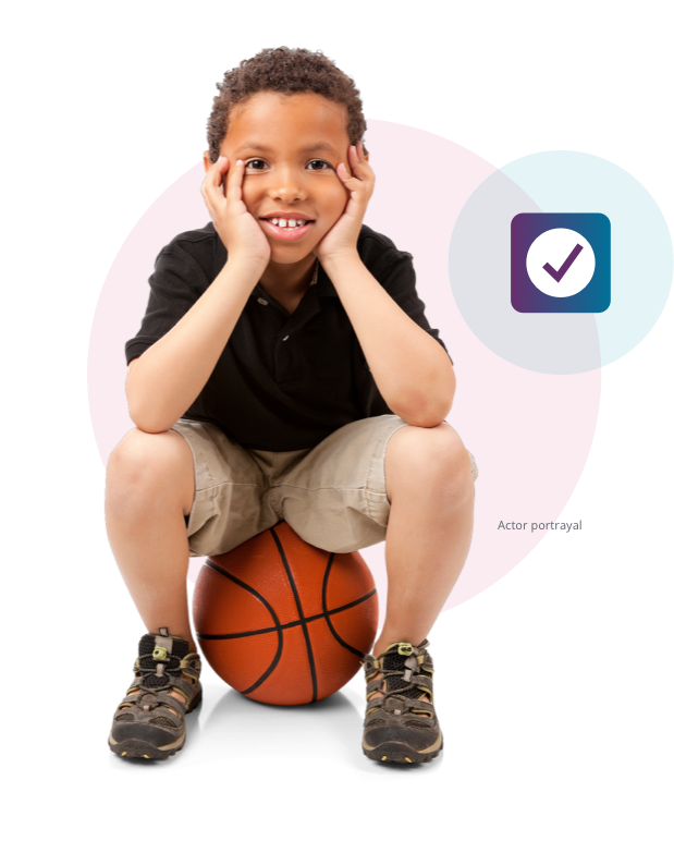 Boy sitting on a basketball